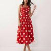 robes à pois rouges dos nu mi-longue habillée lilah portée par une femme avec des sandales blanches et un col halter