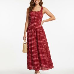 robes rouges à pois blanc longue boutonnée exclusivité carrée taille basse sans manches fluide boutonnée sur le devant portée avec des espadrilles blanches et un petit sac en paille