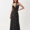 robes vintages rouges à pois noirs et blancs longue caraco encolure foulard portée par un mannequin femme rousse sur un fond blanc neutre