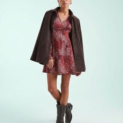 robes à pois rouge col v tachetés courte bordeaux rose portée par mannequin avec veste marron et bottes de motardes
