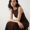 robes à pois transparentes maille encolure bateau tombant longue chocolat sans manches portée par un mannequin