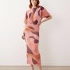 robes à pois jaune dénudées motif longue épaules plissée imprimé rose fluide élégante à manches courtes portée par un mannequin aux cheveux roux