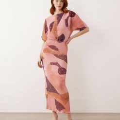 robes à pois jaune dénudées motif longue épaules plissée imprimé rose fluide élégante à manches courtes portée par un mannequin aux cheveux roux