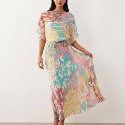 robes à pois jaune bleu longue plissée épaules dénudées métallisé motif bleu ciel fluide à col bateau portée par une femme avec des sandales dorées