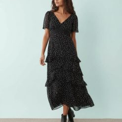 robes longues noires à pois mousseline étagés volants petite col en v et manches courtes portee avec des bottines noires