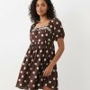 robes années 60 manches bouffantes babydoll courte pois bleu marron à col carré et détails en dentelle portée par une femme