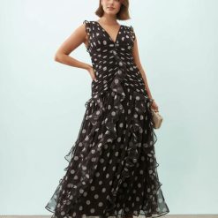 robes à pois grandes tailles longue froncée cascade détail marron portée par un modèle avec des volants élégants et des motifs à pois sur toute la longueur