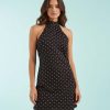 robes à pois jaune marron courte et dos nu portée par un mannequin sur fond bleu clair