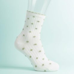 chaussettes à pois multi design crème et olive portées par une femme avec une tenue courte blanche sur fond blanc
