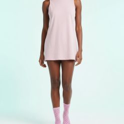 chaussettes à pois violets avec style original pour femme portées avec un haut rose sans manches
