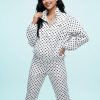 vestes à pois col cheminée blanc et ensemble pantalon assorti porté par un mannequin sur fond bleu clair