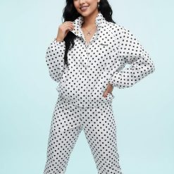 vestes à pois col cheminée blanc et ensemble pantalon assorti porté par un mannequin sur fond bleu clair