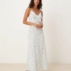 nuisettes à pois longue corsage robe volanté petite blanc neige à bretelles fines imprimé pois noirs sur fond blanc portée par un mannequin vindt-on