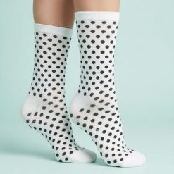chaussettes à pois noir et blanc femme coton mi haute avec talon et pointe blancs sur fond bleu pastel