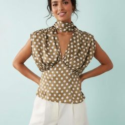 blouses à pois ivoire satinée détails avec foulard bouffants vert kaki sans manches ajustée à la taille