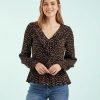 blouses à pois volantés détails blanc grain de café portée par une femme avec des manches longues et col en v