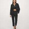 blazers à pois monochrome ensemble pantacourt bandeau sans col porte par un mannequin femme avec escarpins noirs