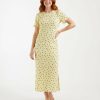 robes moulantes à pois jersey texturé longue en vanille française portée par un mannequin aux cheveux roux avec des manches courtes
