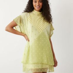 robes asymétriques à pois lemon blousante courte manches ange portée par une femme au col montant sur fond blanc