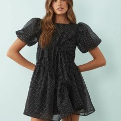 robes asymétriques à pois noir courte manches bouffantes crépon exclusivité portée par un mannequin avec détails drapés
