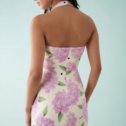 robes vintages rouges à pois imprimé dos nu courte fleurs violet fleuri vue de dos montrant une robe moulante fleurie violette avec motif pois noir sur fond beige