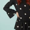 robes à pois rouge volants étagés fluide courte et noir avec manches longues évasées à volants portée par une femme