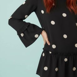 robes à pois rouge volants étagés fluide courte et noir avec manches longues évasées à volants portée par une femme