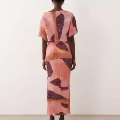 robes à pois jaune dénudées motif longue épaules plissée imprimé rose vue de dos mannequin femme portant une tenue longue fluide imprimee avec des talons dores