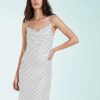 robes mousseline à pois bretelles fines col bénitier blanc neige portée par un mannequin sur fond clair avec une coupe fluide et élégante