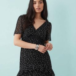 robes longues noires à pois étagés en mousseline volants portée par une femme avec col en v et manches courtes