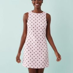 robes droites à pois roses en denim rayures portée par une femme souriante sur un fond bleu clair