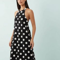 robes portefeuille à pois noir et blanc trapèze midi design col halter portée par une femme