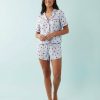 pyjamas à pois ensemble satin courtes manches chemise bleu imprimé rouge porté par une femme sur fond bleu clair