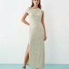 robes asymétriques à pois crème avec tombante épaule mollet longueur et fente latérale portée par un mannequin avec des sandales marron