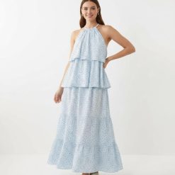 robes bleu ciel à pois volumineuse longue étagés volants portée par une femme sur un fond blanc neutre