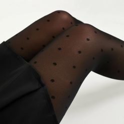 collants à pois noir 20 deniers fantaisie voile femme portés par un mannequin avec une jupe noire sur fond blanc