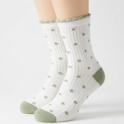 chaussettes à pois multi design crème et olive portées par une femme qui porte une nuisette blanche