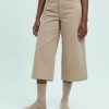 chaussettes à pois beiges avec paillettes brillantes femme portées avec un pantalon beige court