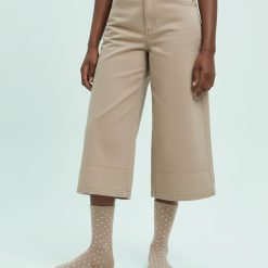 chaussettes à pois beiges avec paillettes brillantes femme portées avec un pantalon beige court