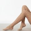 collants à pois transparents exclusivité nude femme voile style portes sur les jambes de mannequin posees sur un tapis clair avec fond blanc