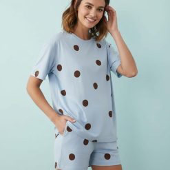 pyjamas à pois bleu chocolat ensemble short t-shirt oversize maternity porté par une femme souriante sur un fond bleu clair