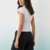 blouses à pois blancs courtes style goutte corset découpe manches portée par une femme vue de dos avec un pantalon noir