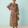 blouses à pois ample encolure ronde nœuds marrons blancs portée par une femme avec une jupe assortie et des chaussures marron
