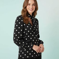 blouses à pois noirs et blancs avec détail foulard col en v portée par un mannequin femme aux cheveux marron