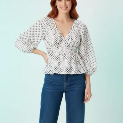 blouses à pois ballon manches mode femme chic élégant blanche avec col v et taille froncée portée par une femme avec un jean
