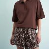 caleçons à pois marron style short en satin porté par une femme avec un polo marron à manches courtes
