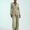 blazers à pois olive encolure ronde avec lin mélangé porté par une femme avec un pantalon assorti