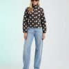 vestes à pois en col jean avec cheminée ajustée marron avec pois bleu ciel portée par un mannequin femme avec un jean large bleu clair