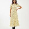 robes moulantes à pois jersey texturé longue en vanille française jaune claire à manches courtes et bottines noires sur fond blanc