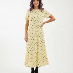 robes moulantes à pois jersey texturé longue en vanille française jaune claire à manches courtes et bottines noires sur fond blanc